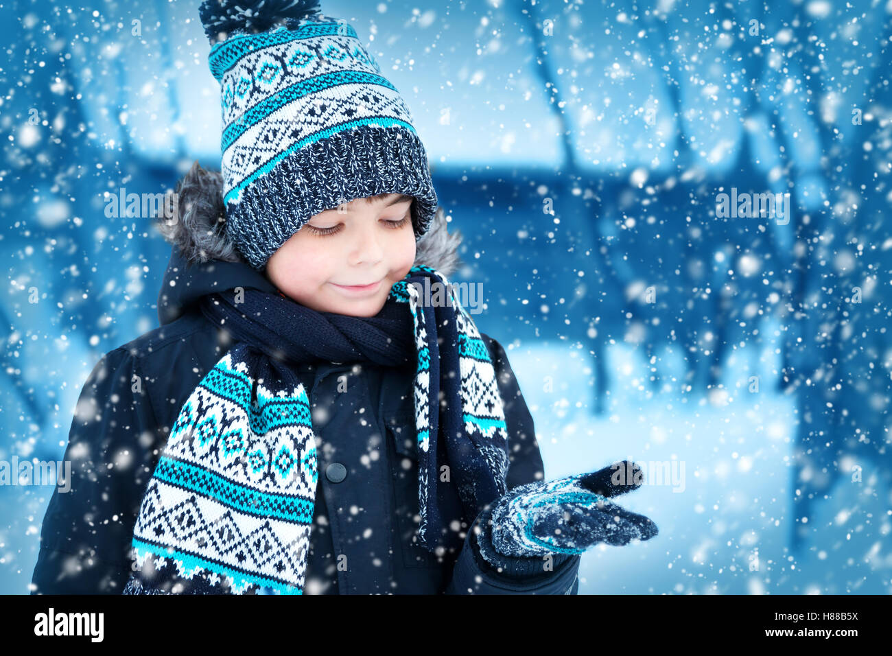 Boy in knitted hat gloves and scarf outdoors at snowfall Stock Photo Alamy