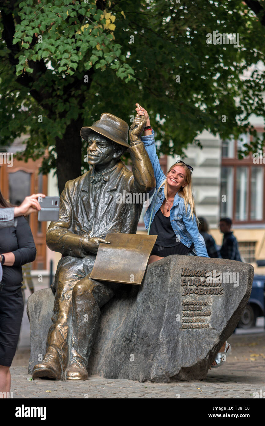 People posing in front of the Monument of Nikifor Krynicki in lviv,Ukraine Stock Photo