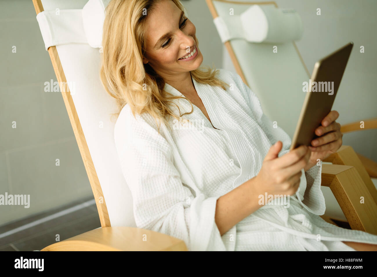 Beautiful woman relaxing in spa center and using tablet Stock Photo - Alamy