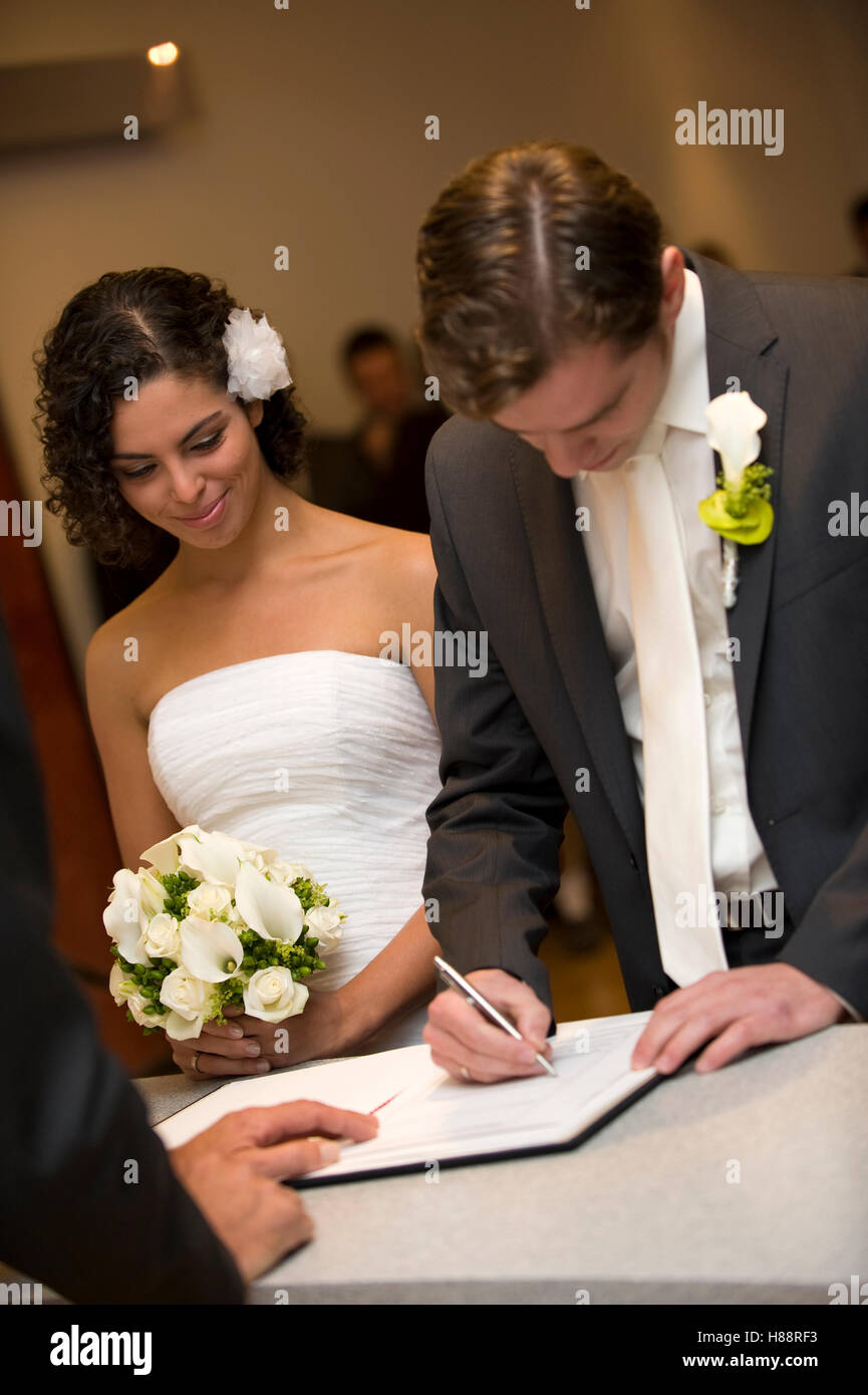 Civil ceremony, groom signing a marriage certificate at the registry