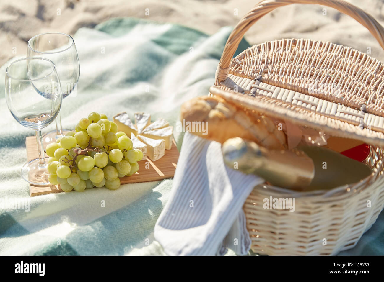 picnic basket with wine glasses and food on beach Stock Photo Alamy