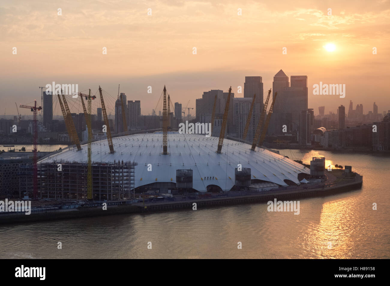 The O2 Arena and Canary Wharf district seen across the Thames at sunset, London England United Kingdom UK Stock Photo