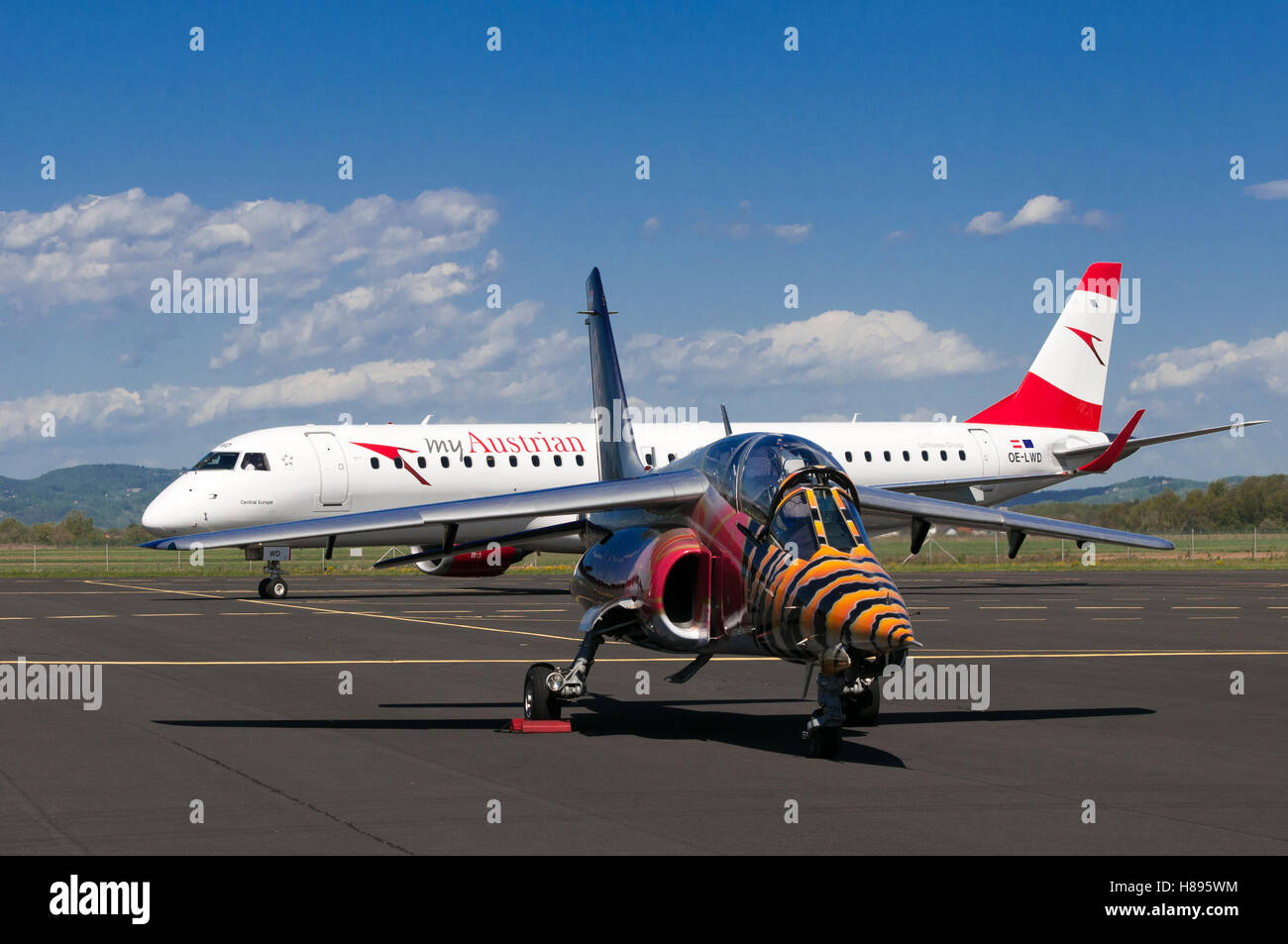 Maribor, Slovenia - April 16, 2016: Red Bull Alpha Jet in front and Austrian Airlines Embraer OE-LWD on apron at Maribor airport Stock Photo