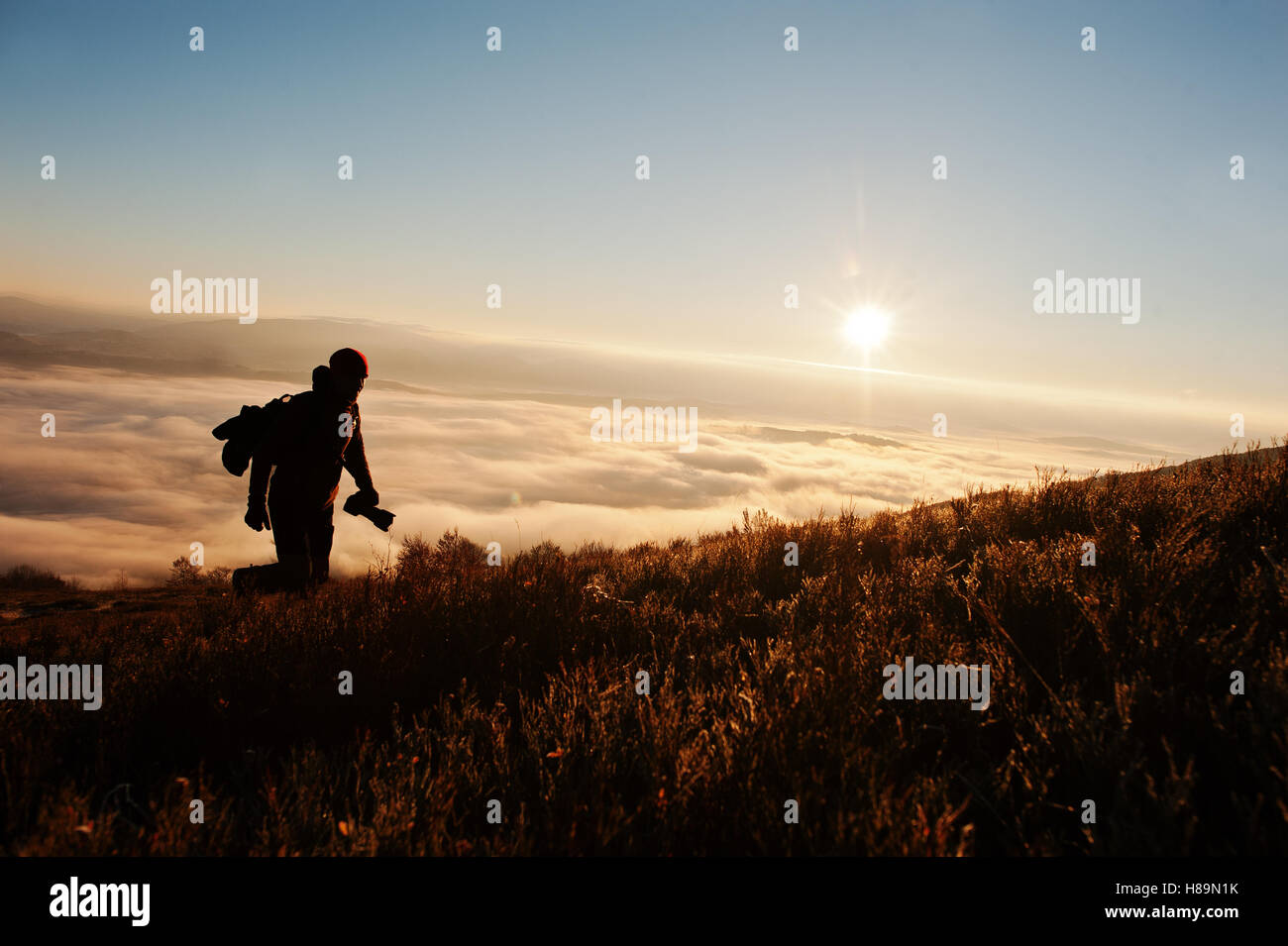 Silhouette of man photographer with camera on hand background mountains ...