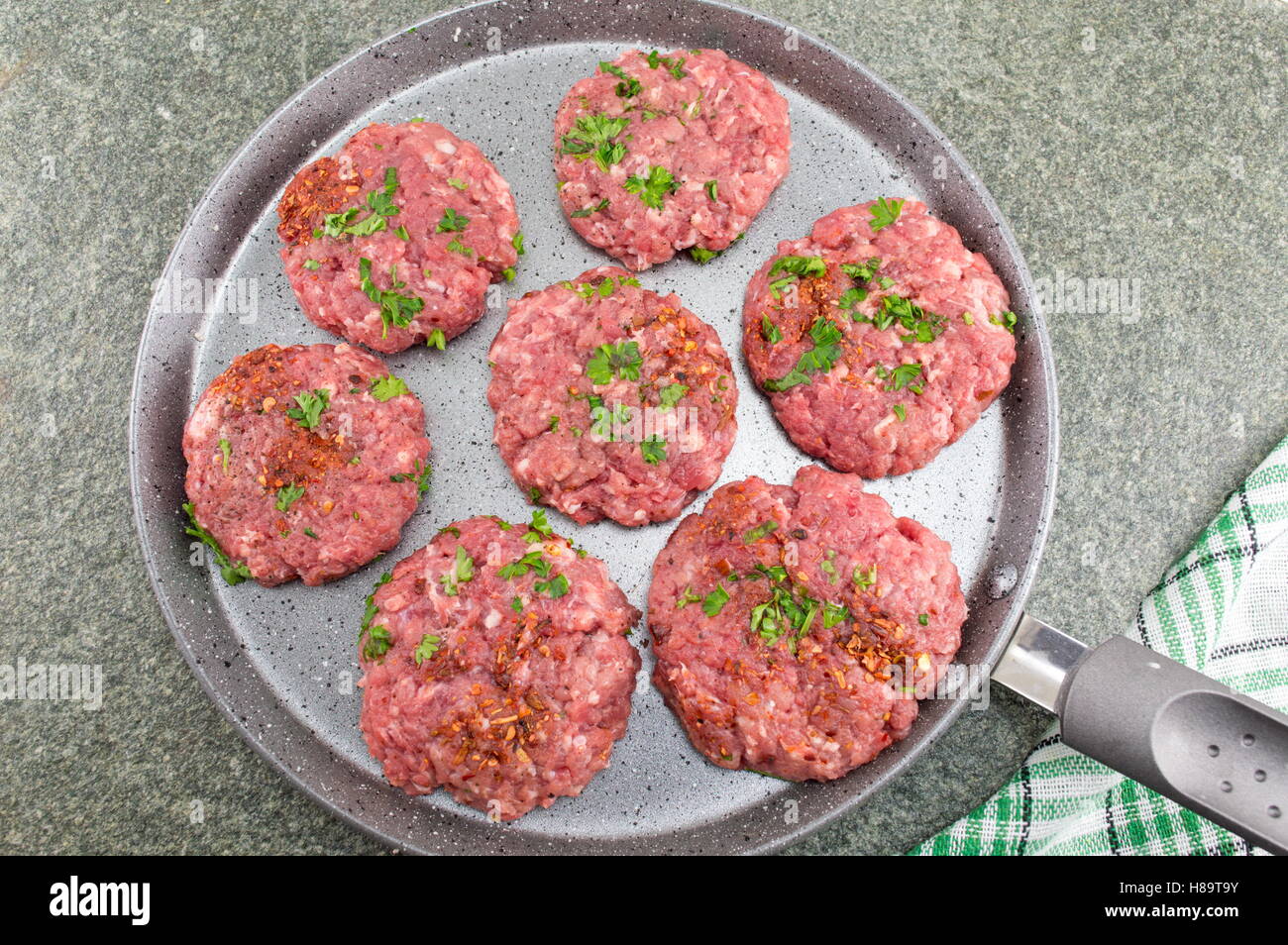 Raw meatballs ready for frying on a stone pan Stock Photo