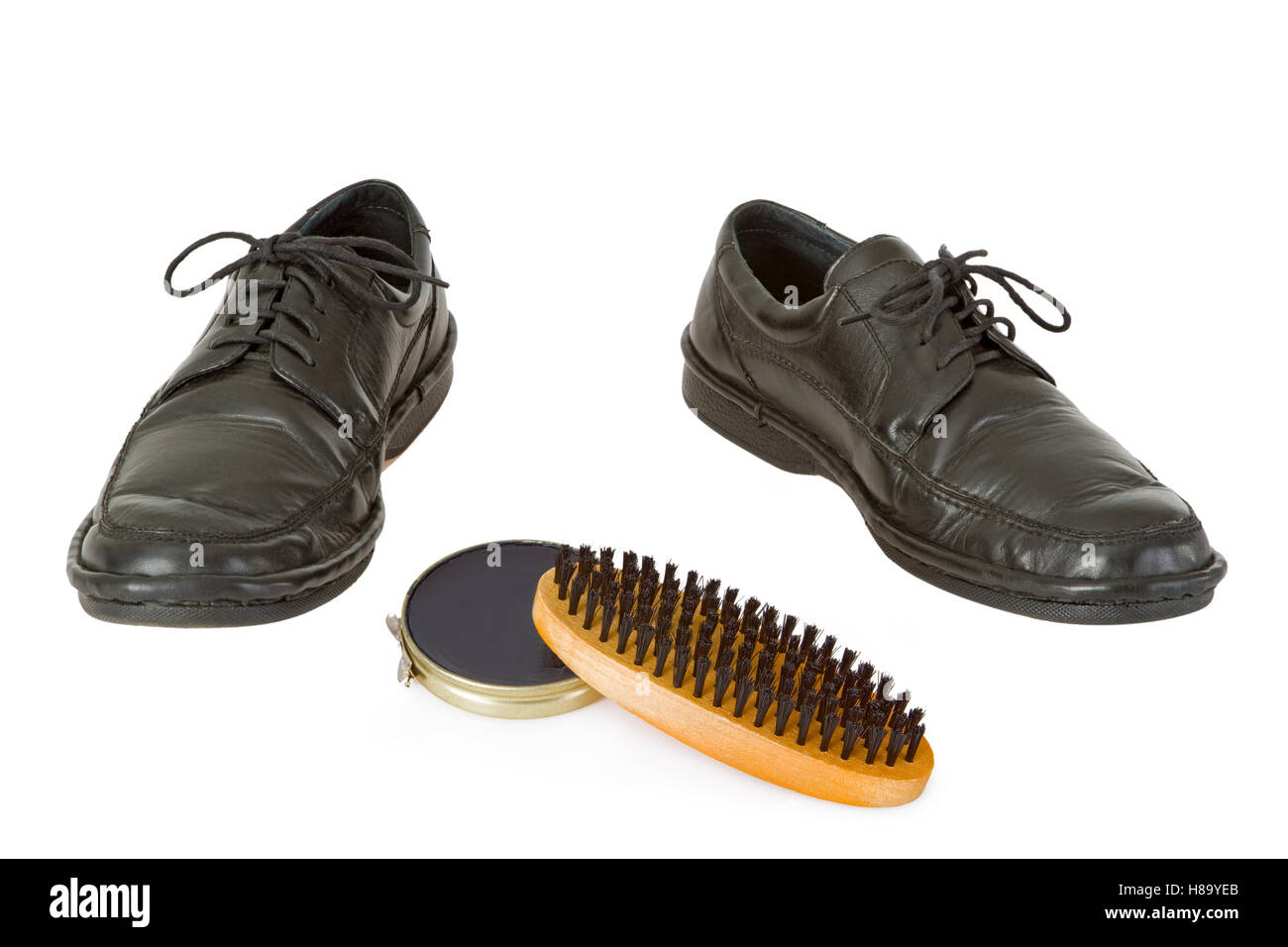 Black men's shoe with shoe polish and brush isolated on white