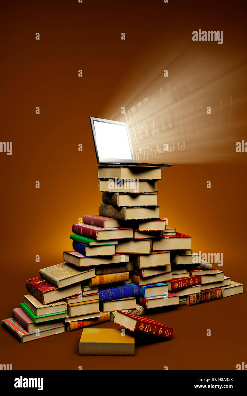 laptop on top of a stack of books Stock Photo