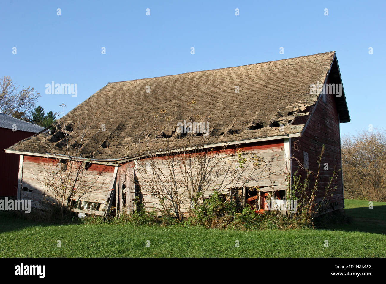 Broken down farm shed with caved in roof and falling sides Stock Photo