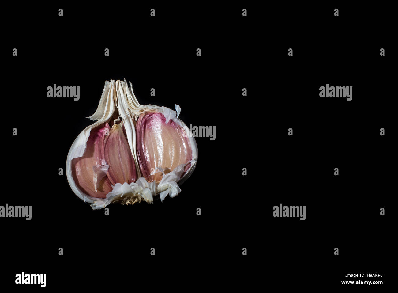 Half a garlic clove on black background Stock Photo Alamy
