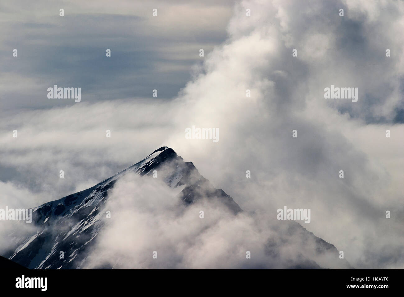 Mountain top shrouded in clouds Stock Photo - Alamy