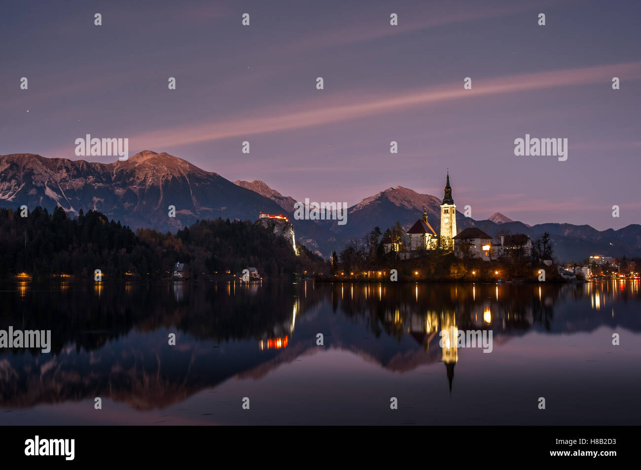 Chapel on a small island at twilight reflected in calm water, Bled lake in Slovenia Stock Photo