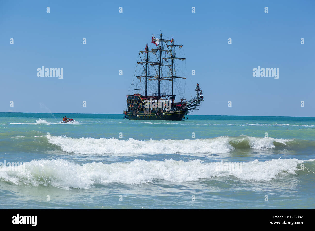 Jet ski is having fun against the background of the sailing ship Stock Photo