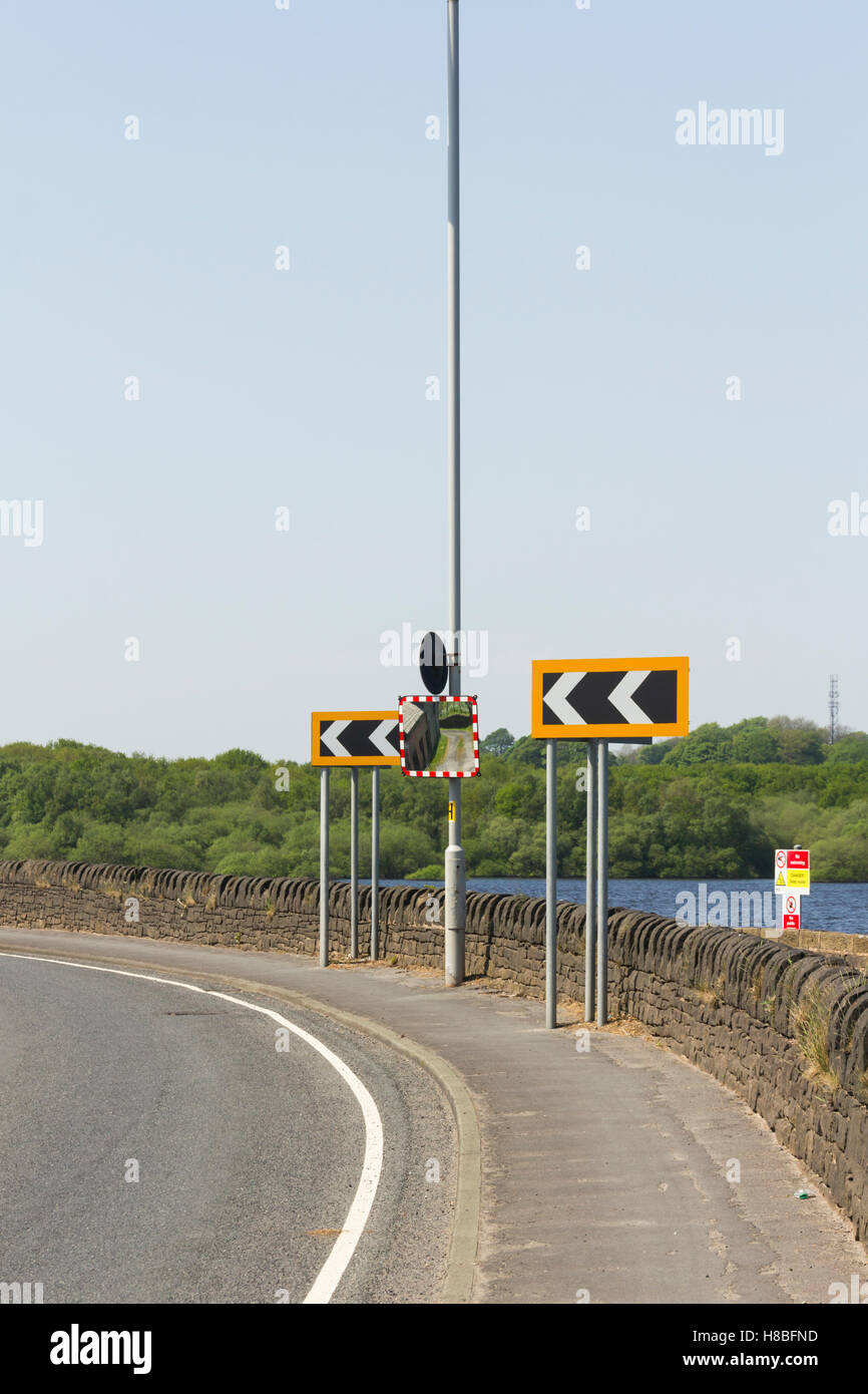 Sharp left hand bend marked with chevron signs on a severe curve on the A673 as it runs past lower Rivington reservoir  near Horwich, Lancashire. Stock Photo