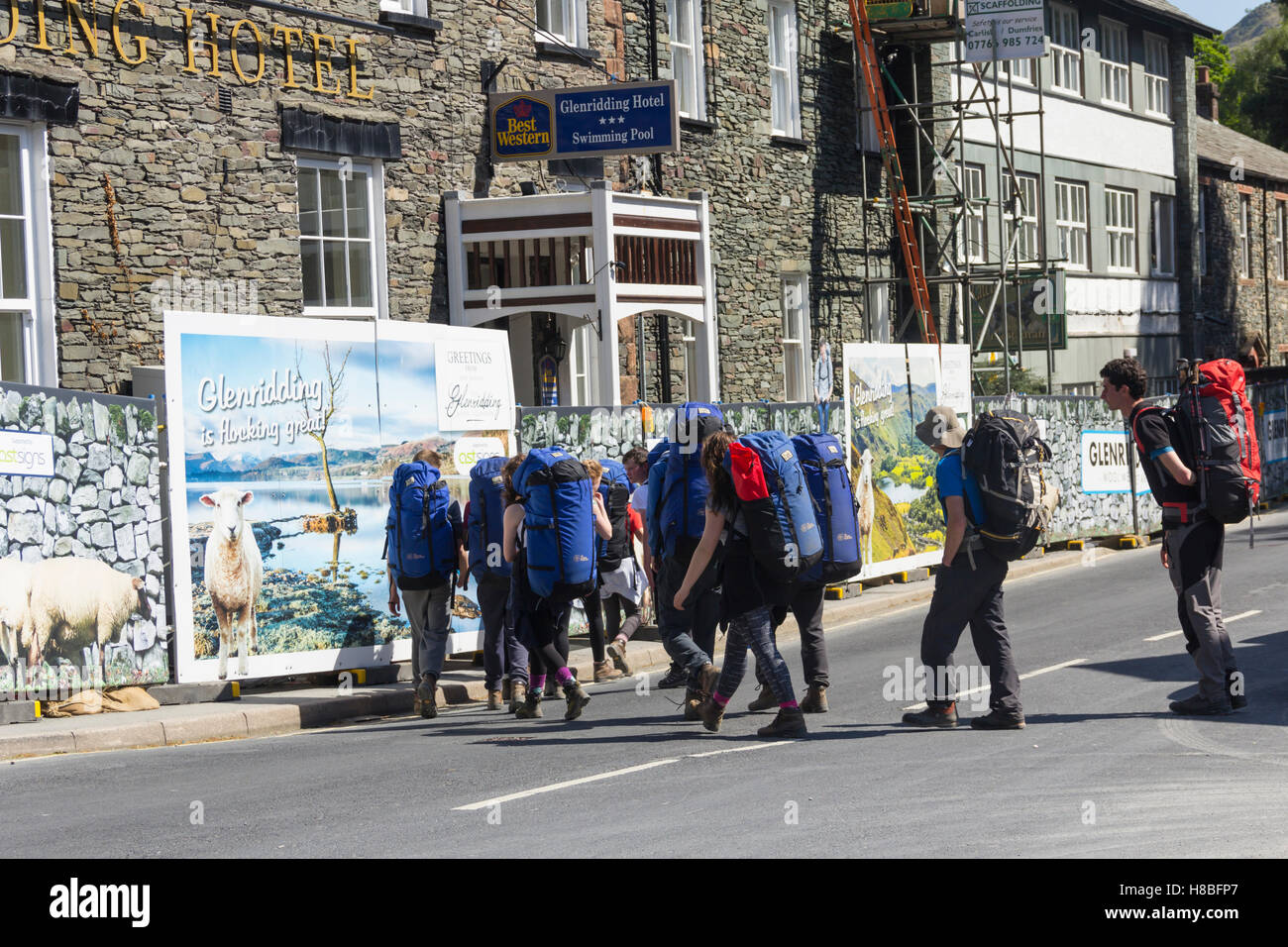 Group of young people with large rucksacks bearing the brand of the Outward Bound Trust in Glenridding, Cumbria Lake District. Stock Photo