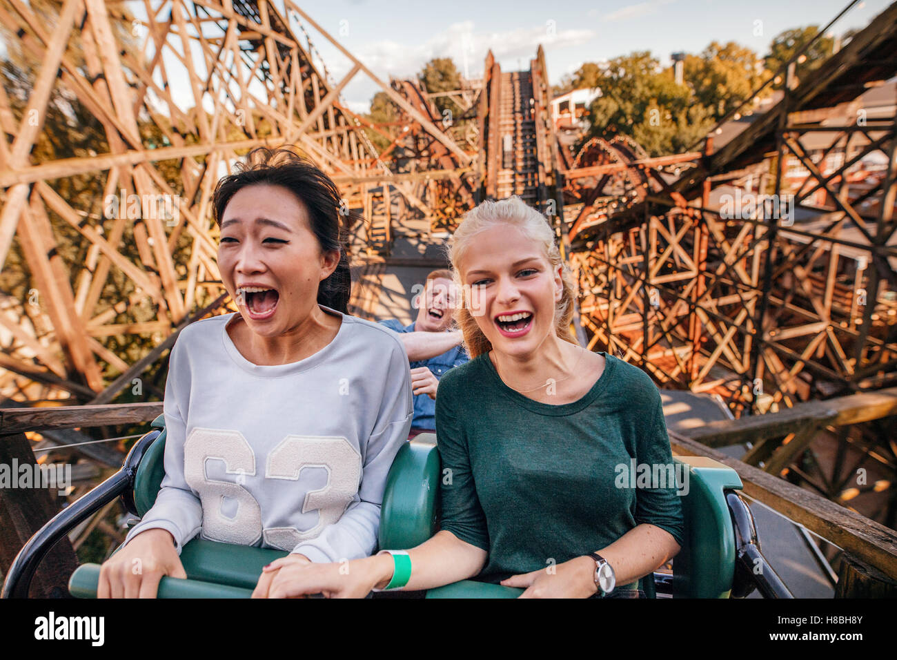 Shot of young friends riding roller coaster ride at amusement park. Young people having fun at amusement park. Stock Photo