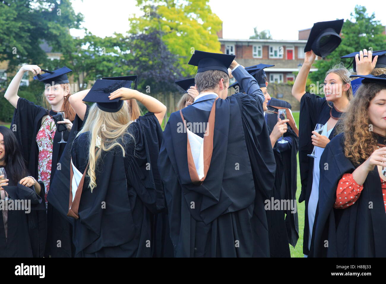 Graduates in gowns holding their mortarboards, Goldsmiths, University of London, England, UK Stock Photo