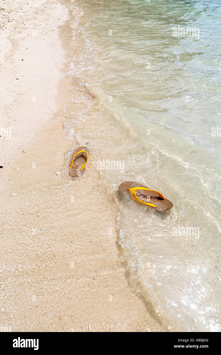 Flip flops on a sandy ocean beach Stock Photo - Alamy