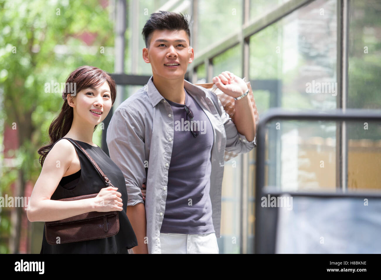Happy young Chinese couple with shopping bags Stock Photo - Alamy