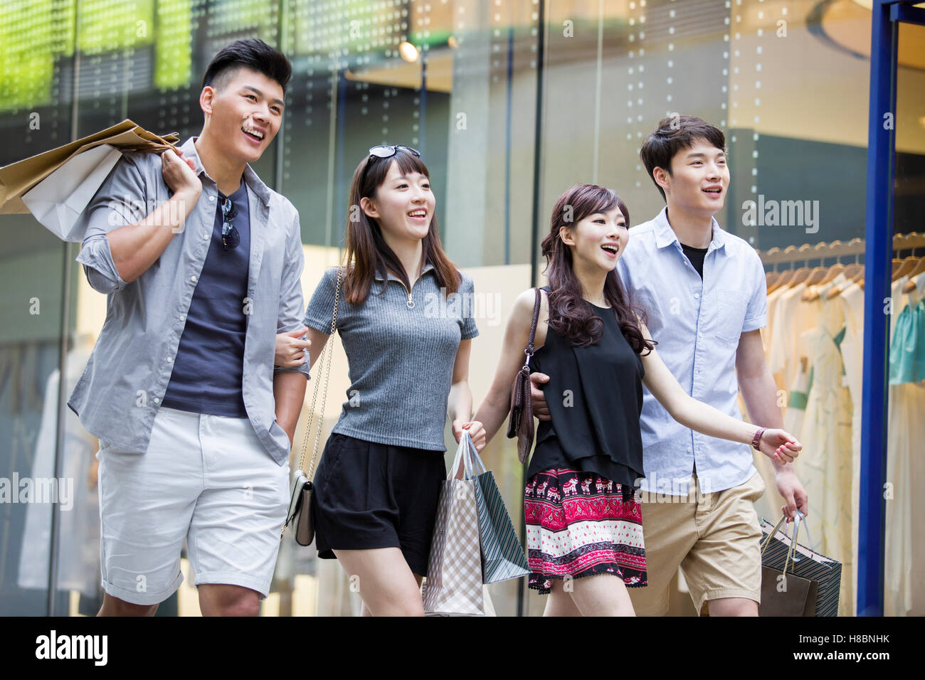 Happy young Chinese friends with shopping bags Stock Photo - Alamy