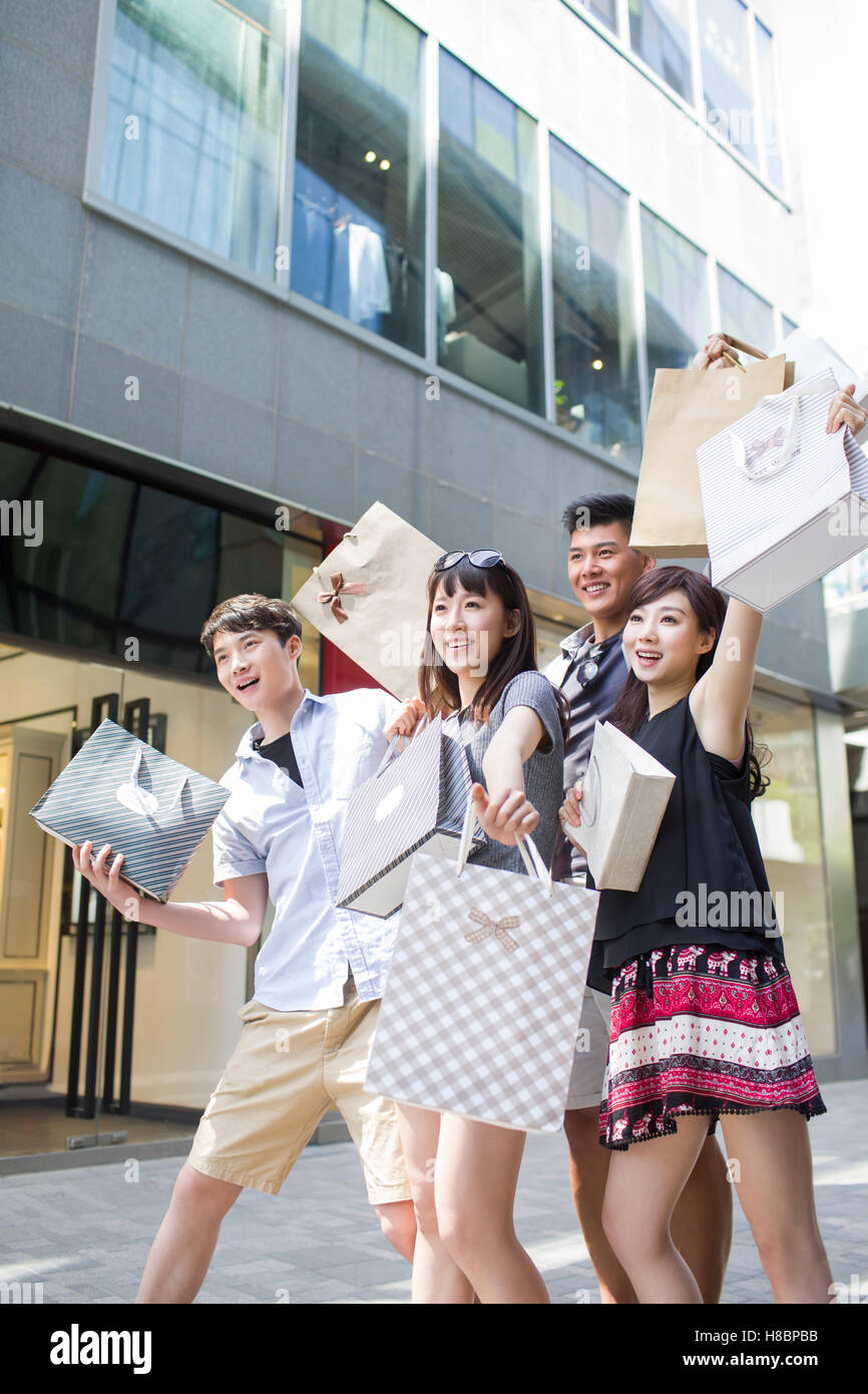 Happy young Chinese friends with shopping bags Stock Photo - Alamy