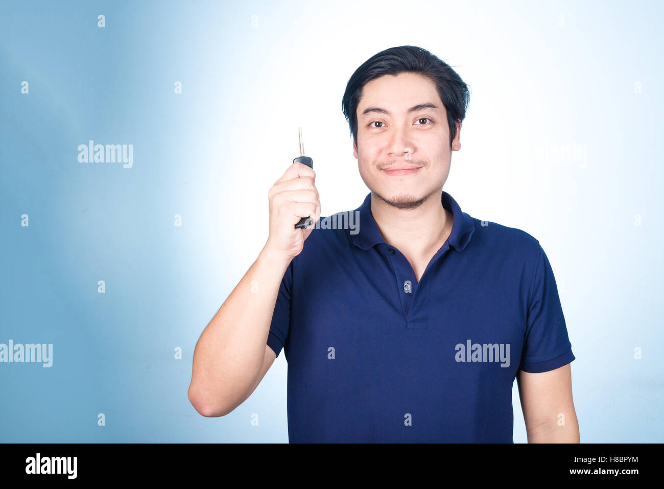 Asian handsome man holding, showing the keys of his new car, on blue ...