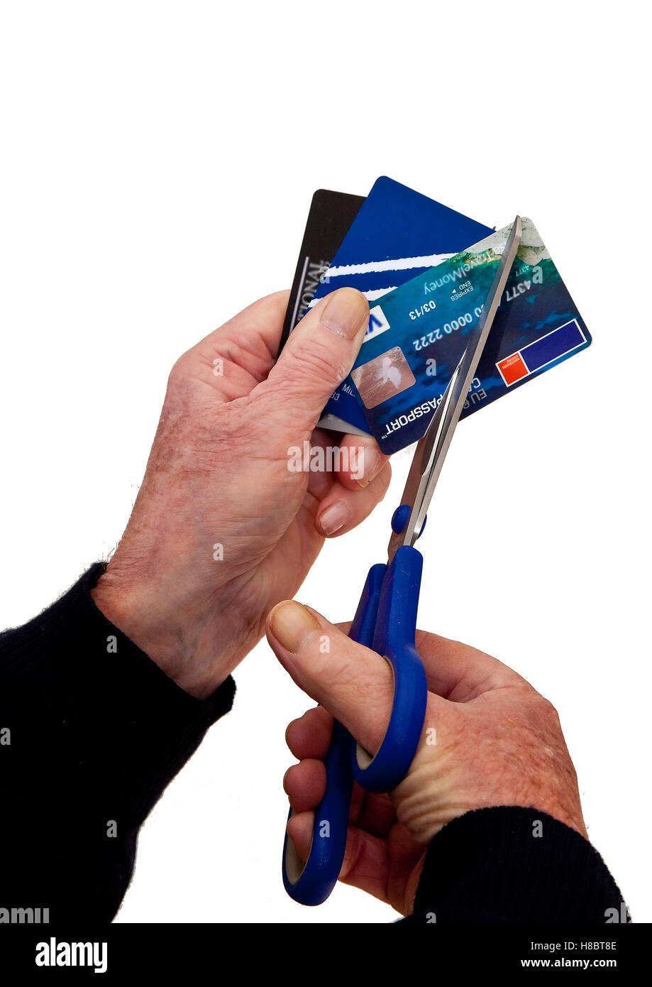 Cutting up credit cards with scissors to remove temptation Stock Photo