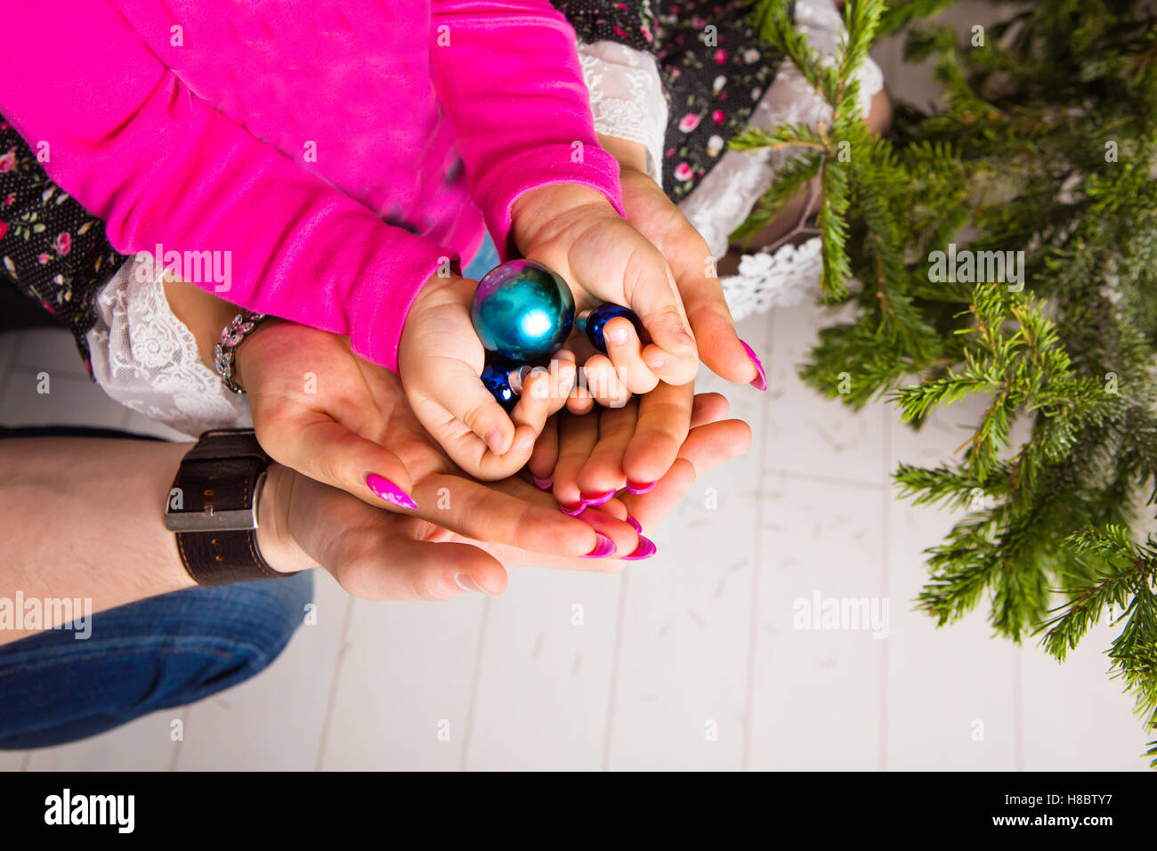 Christmas ball in the hands of the child and father, mother Stock Photo