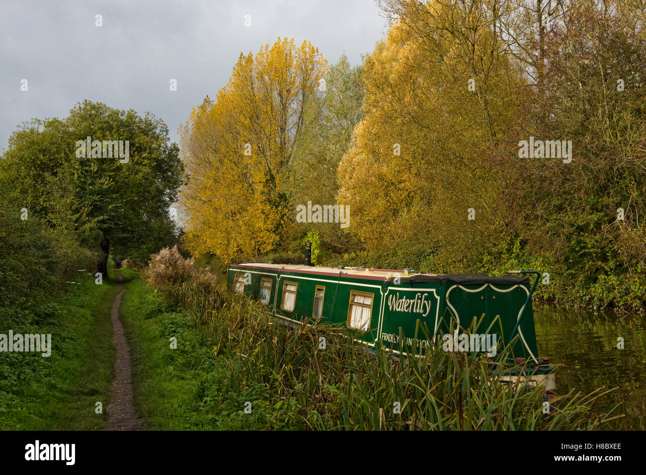 A narrow boat moored by the towpath of the Kennet & Avon Canal on Hungerford Common in autumn, October Stock Photo