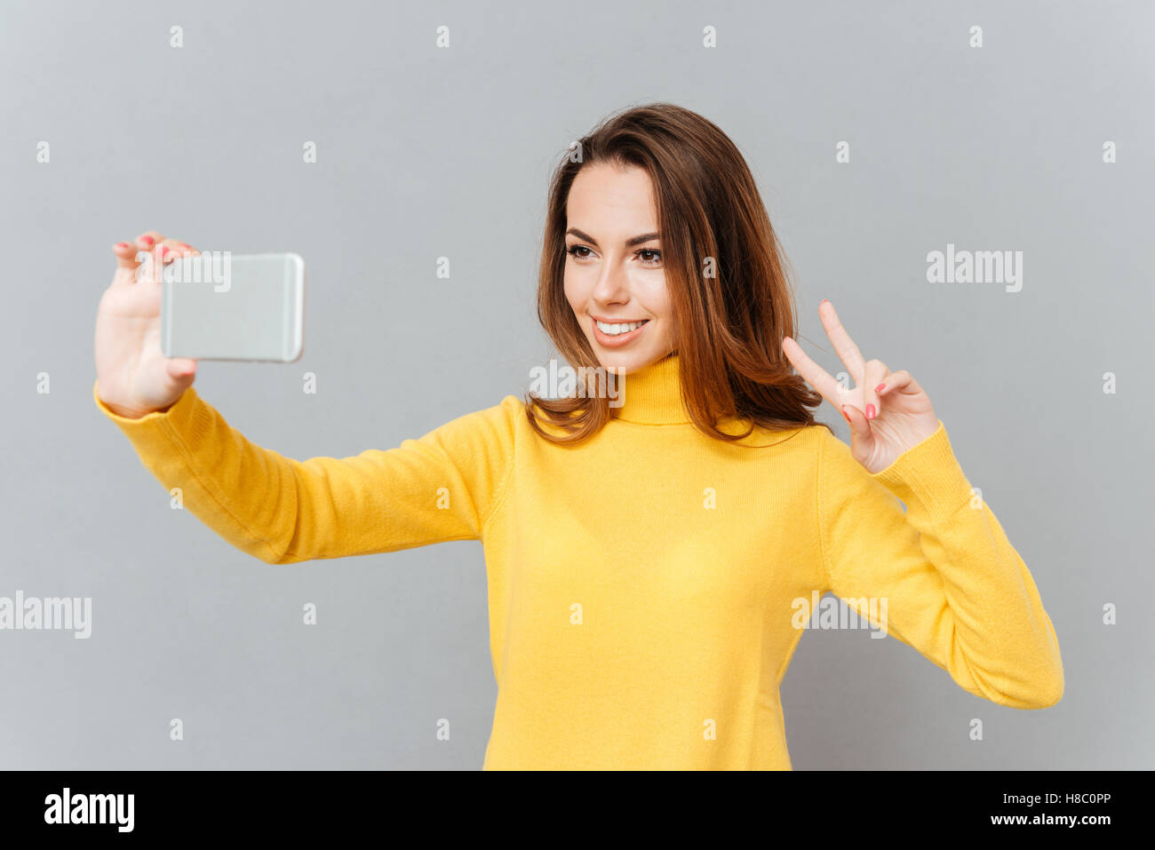 Close up portrait of a cute lovely playful young woman taking selfie ...