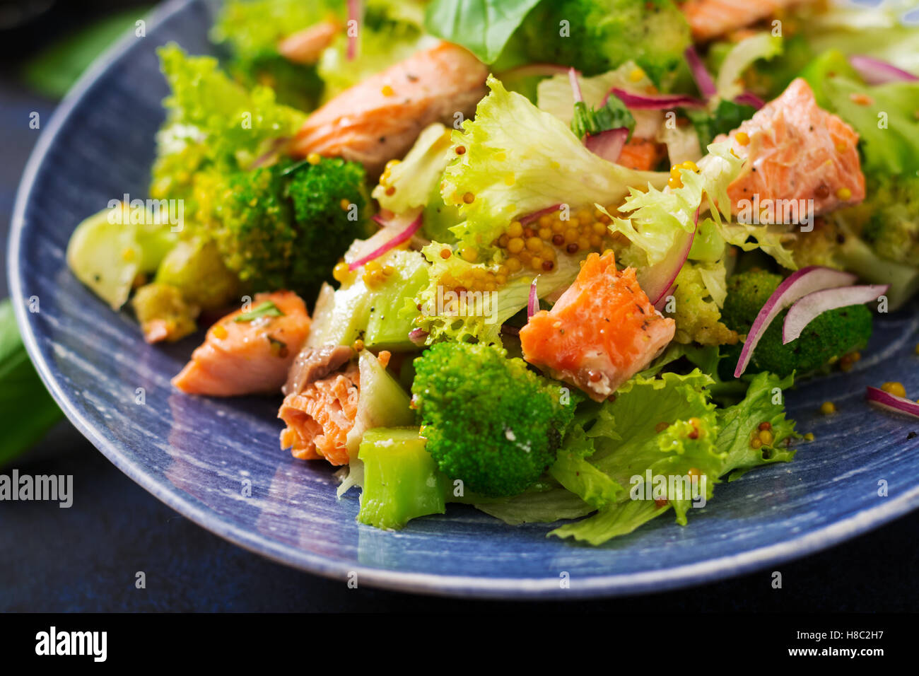 Salad of stewed fish salmon, broccoli, lettuce and dressing. Fish menu