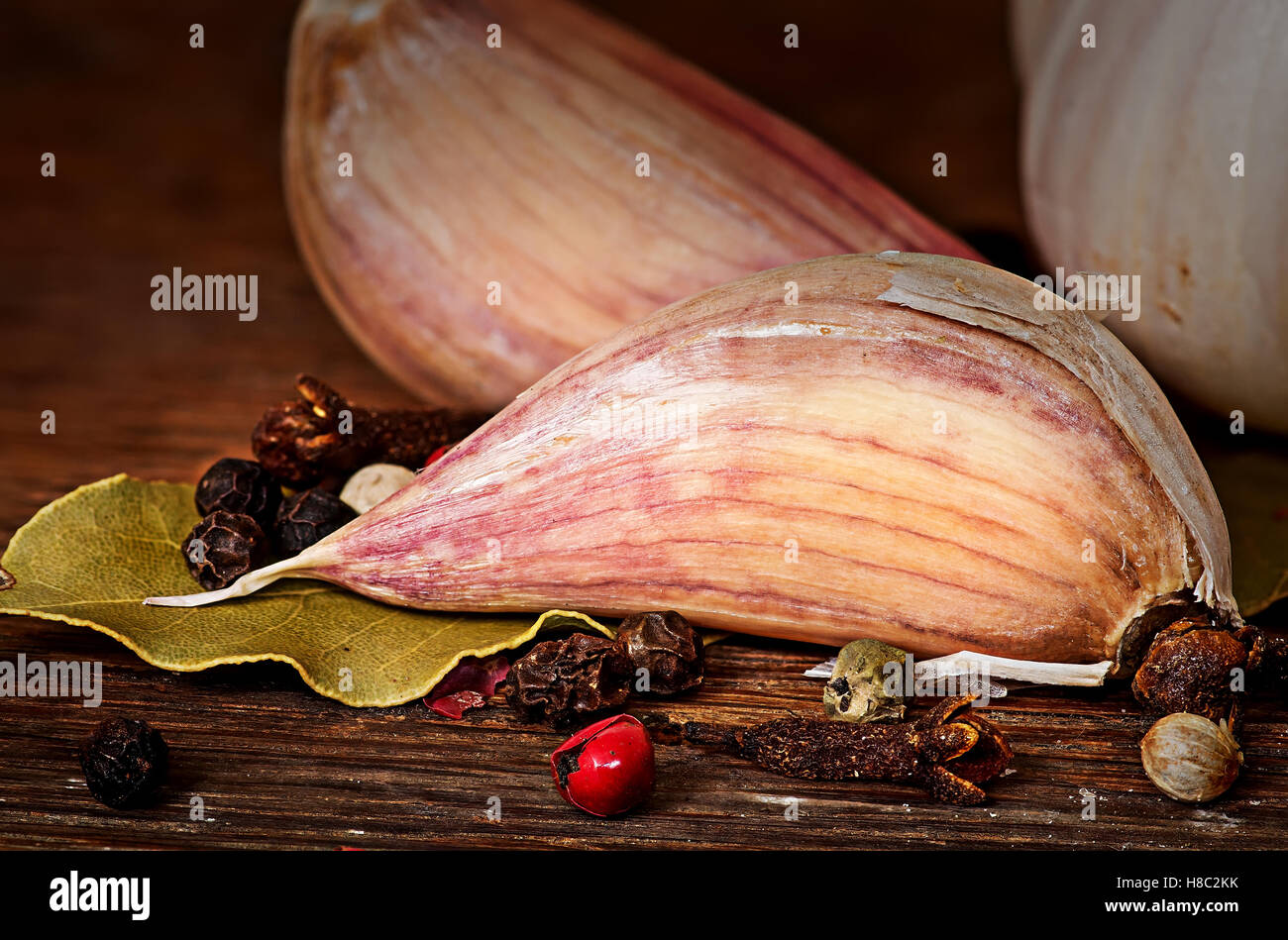 Clove of garlic bay leaf pepper cloves on wooden table Stock Photo
