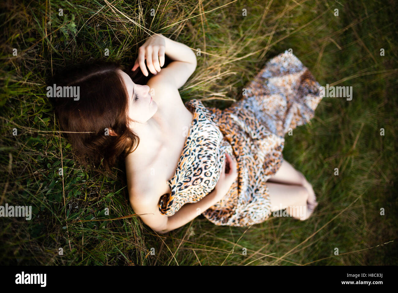 Caucasian long hair girl in spotty dress  lying on the ground. Stock Photo
