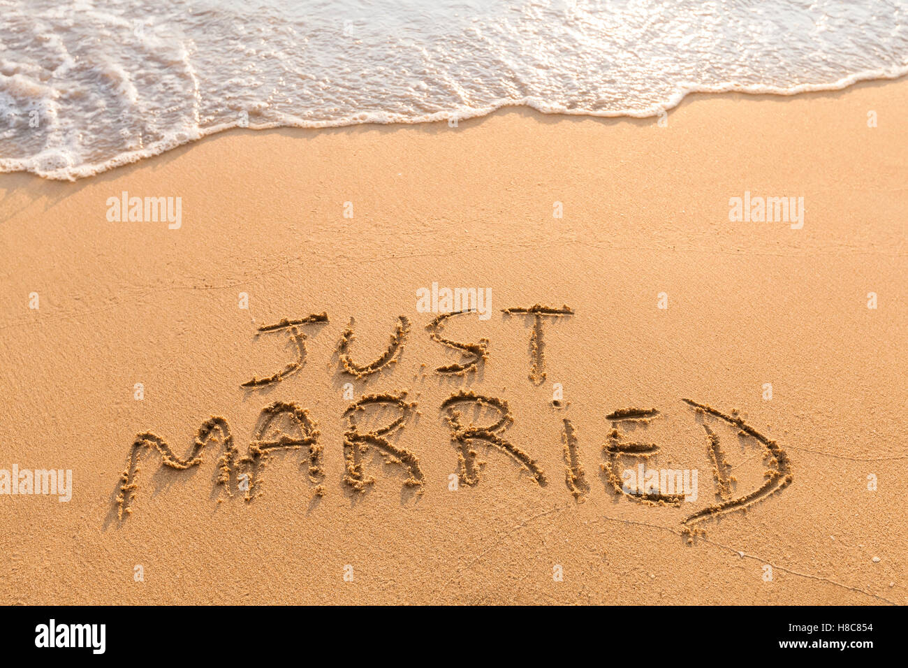 Just married symbol written in the sand on a tropical beach - relaxing honeymoon travel Stock Photo