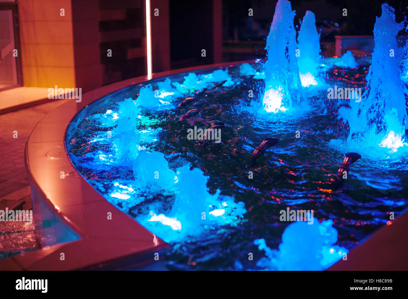 Illuminated colored night fountain in the city Stock Photo - Alamy