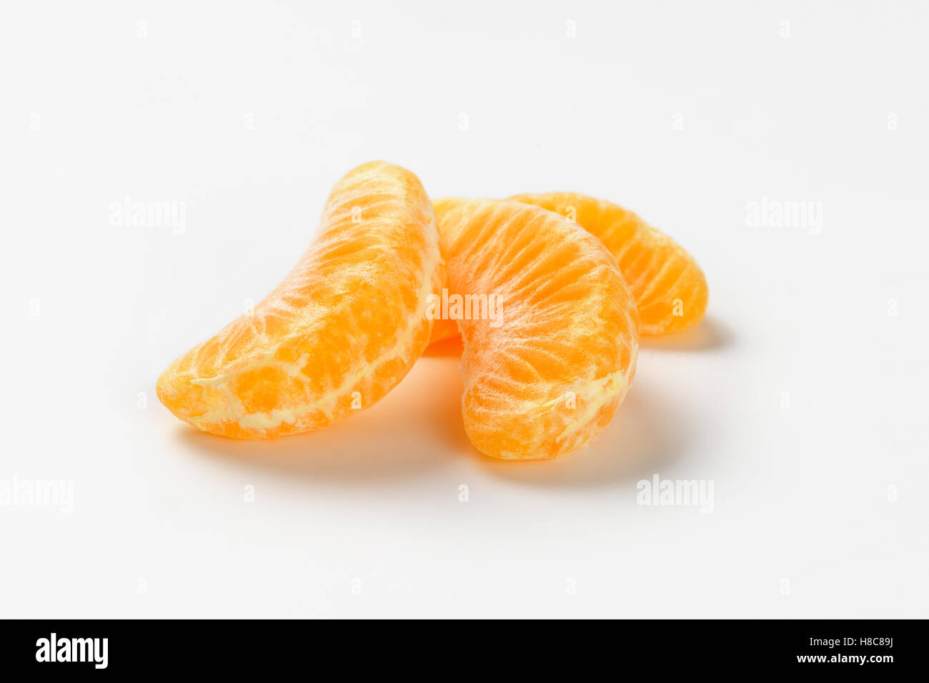 three separated segments of tangerine on white background Stock Photo