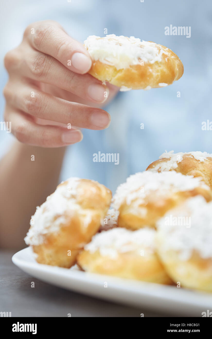 Woman eating eclairs at home. Vertical photos Stock Photo