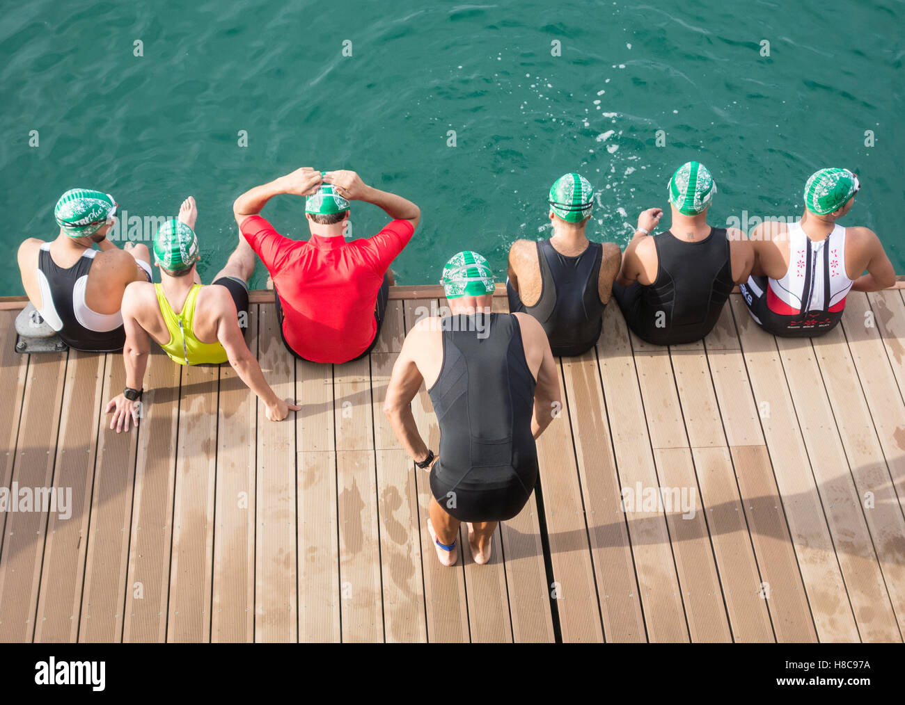 Triathlon swim start. Triathletes in wetsuits at start of race Stock Photo