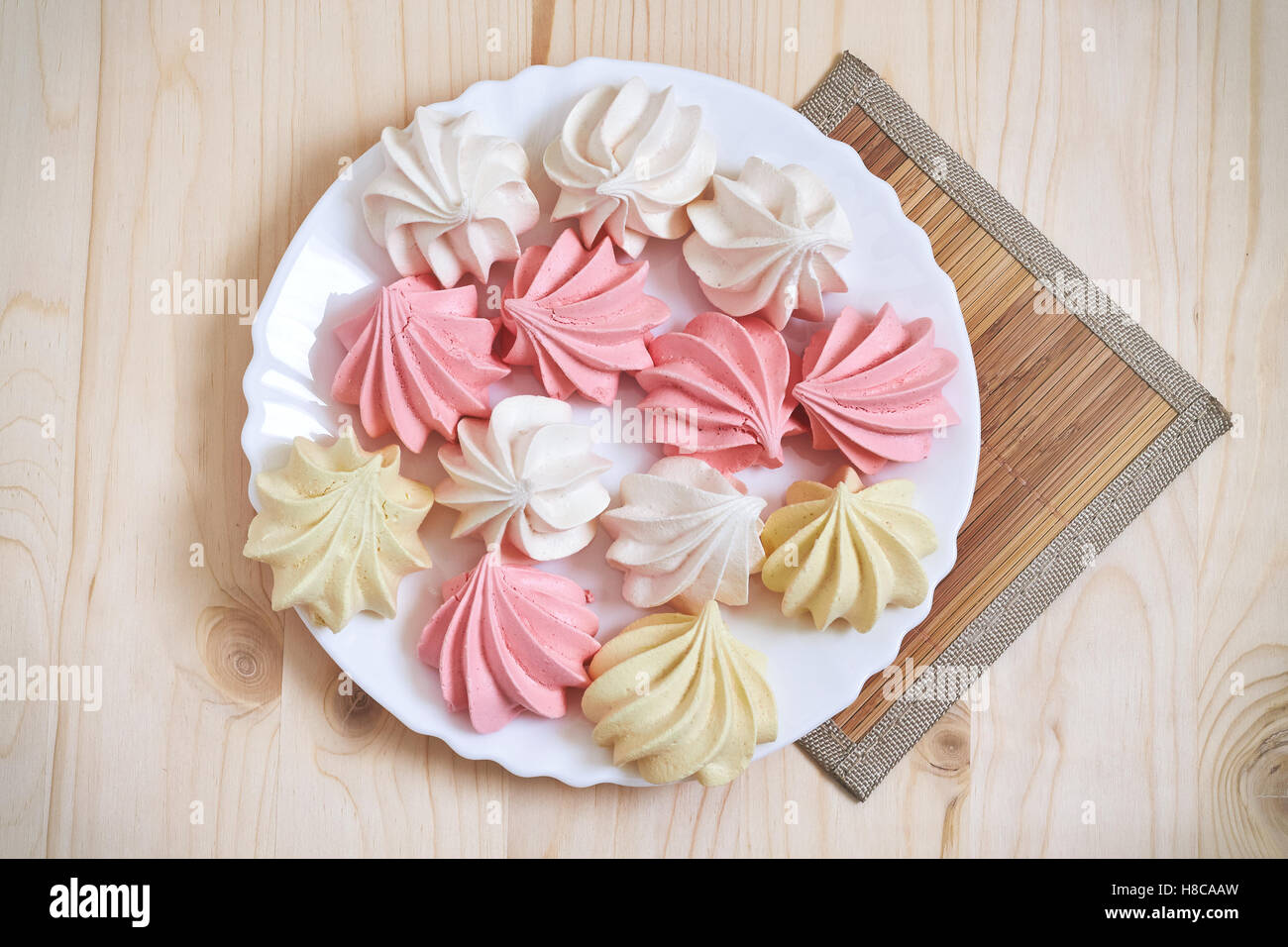 Fresh delicious colored meringue cookies on wooden table. Top view Stock Photo