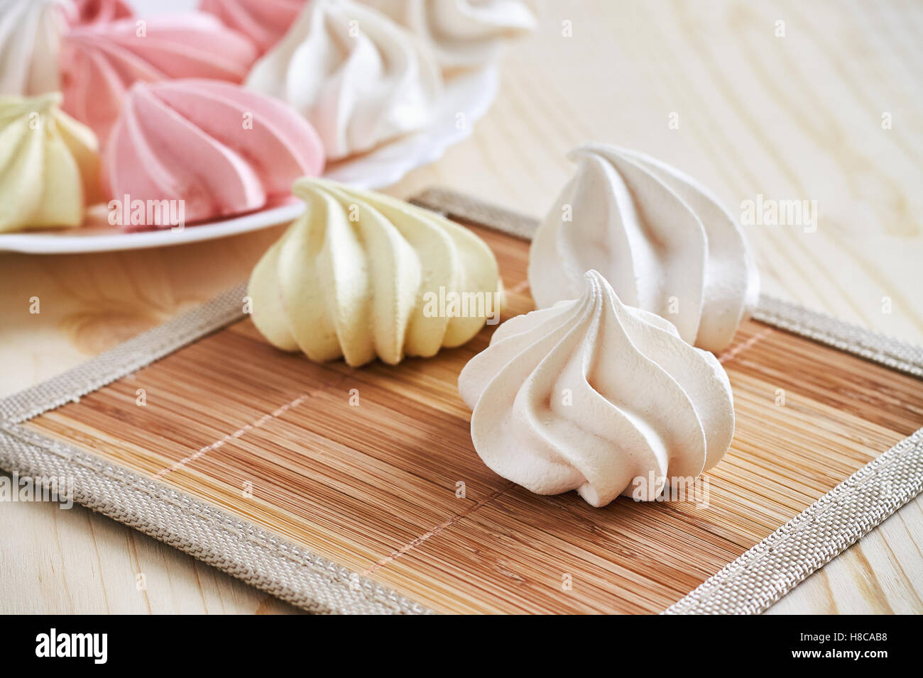 Fresh delicious colored meringue cookies on wooden table Stock Photo