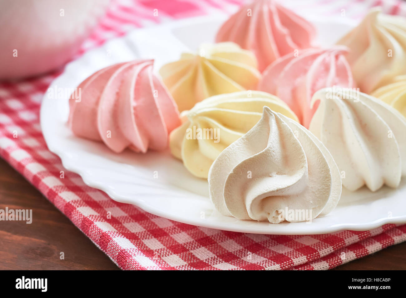 Fresh delicious colored meringue cookies served on white plate Stock Photo