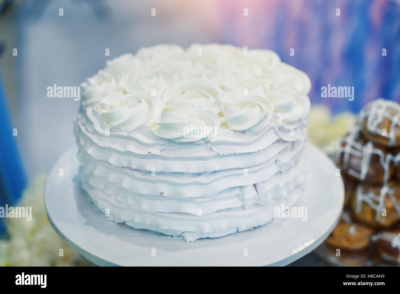 beautiful white wedding cake with flowers on a table Stock Photo