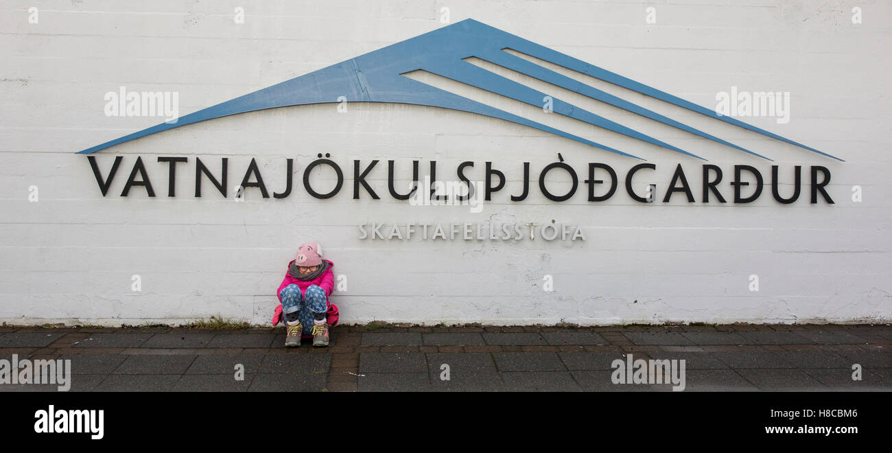 A young girl sits outside the visitor centre at Skaftafell National Park in sourtheastern Iceland Stock Photo