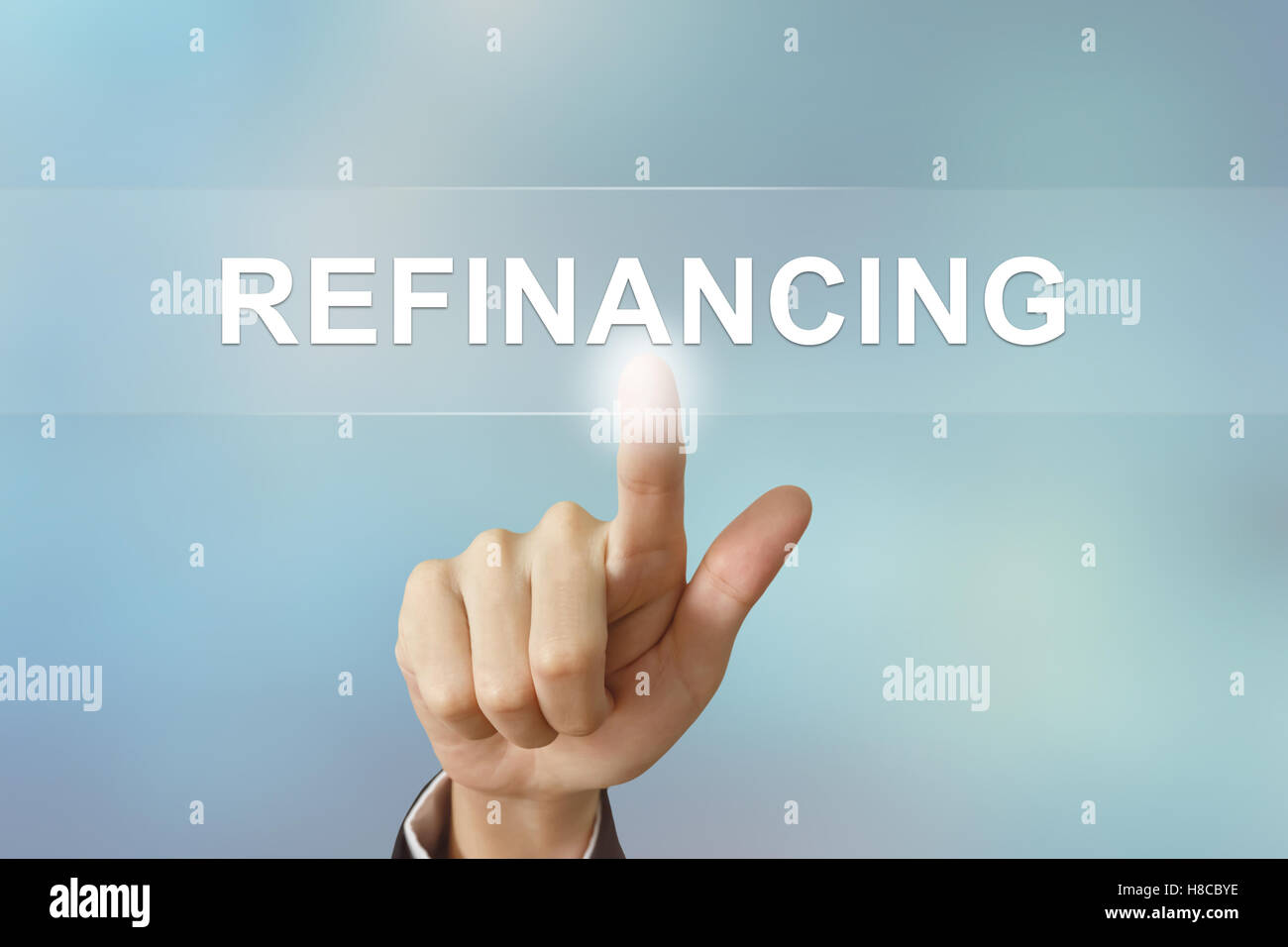 business hand pushing refinancing button on blurred background Stock Photo