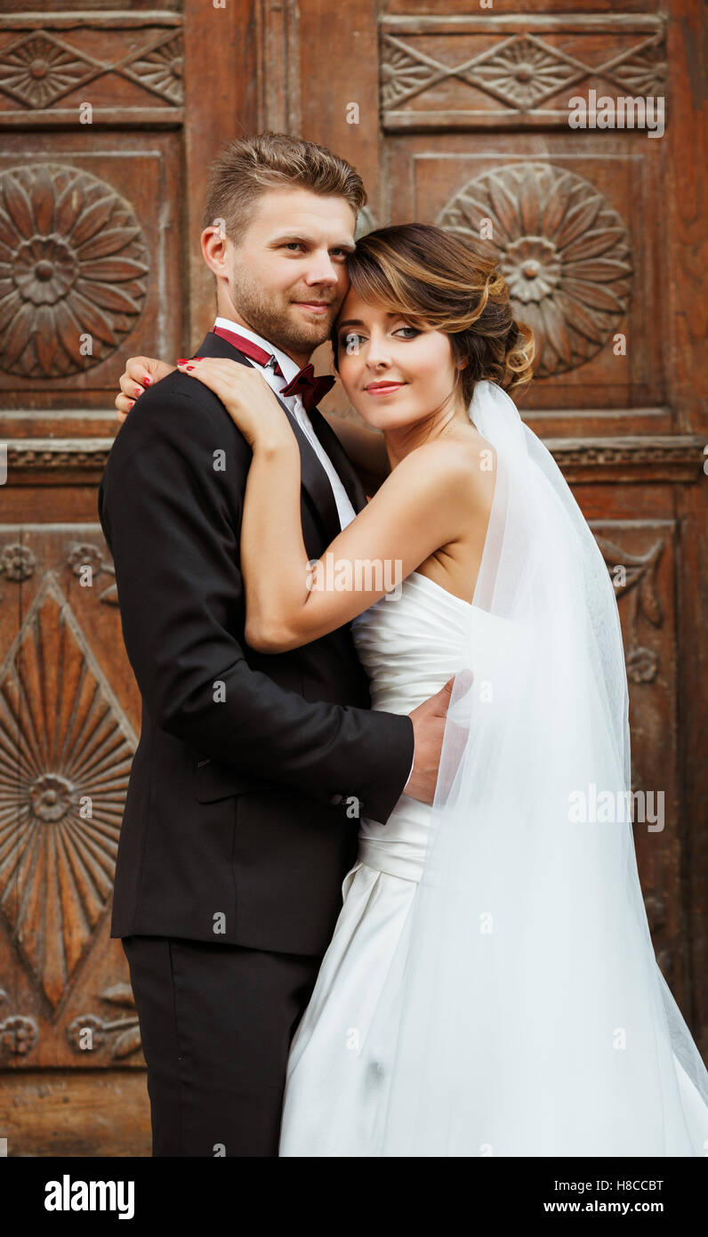 Bridegroom and bride standing near wooden door Stock Photo - Alamy