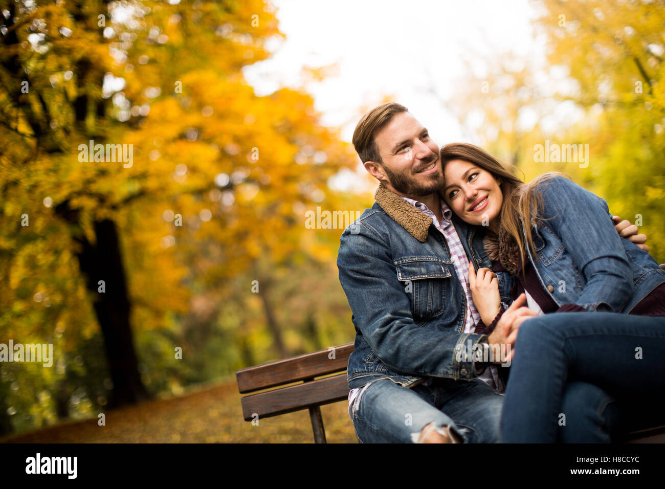 Loving and romantic couple on a bench in the autumn park Stock Photo
