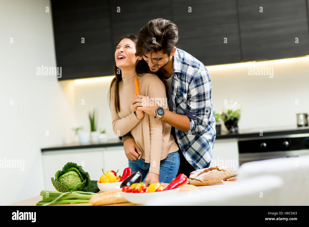 Young couple having fun while preparing food in the kitchen Stock Photo