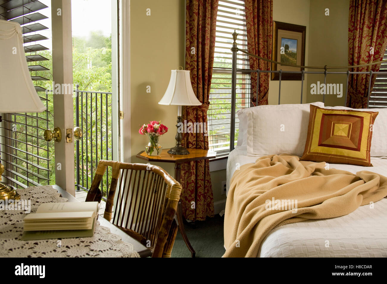 Bedroom With Desk Next To Iron Cast Bed With Open Doorway