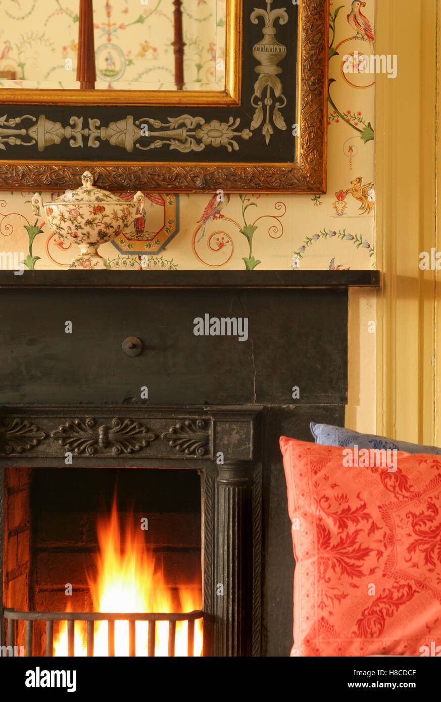 Close up of period style fireplace with lit fire. Stock Photo