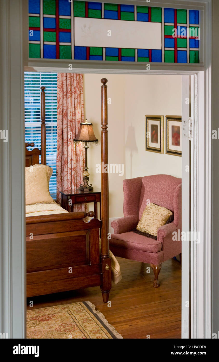 View through open door to armchair next to double bed Stock Photo Alamy