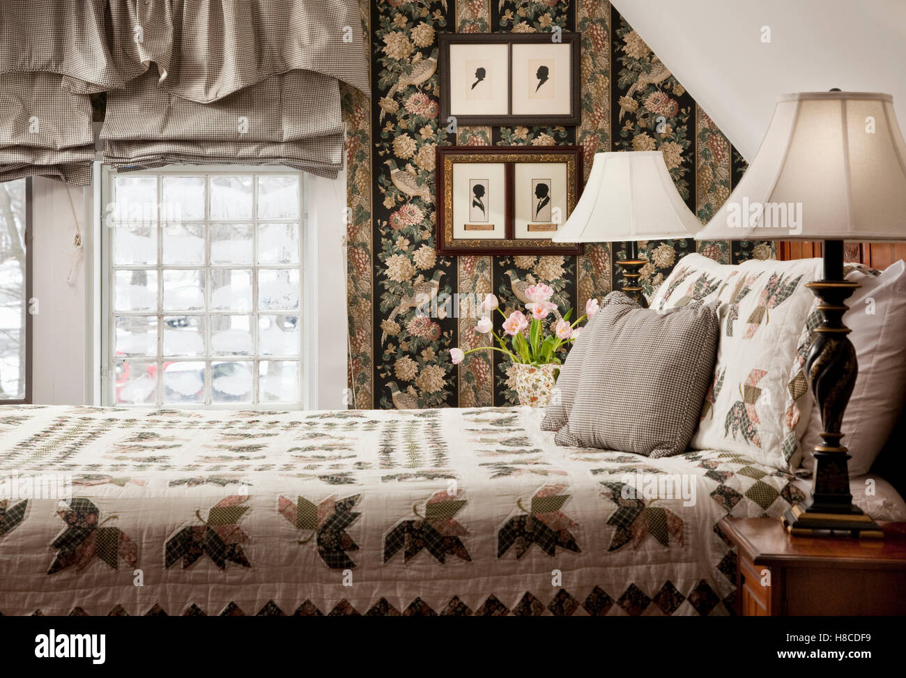 Lamp on bedside cabinet next to double bed. Stock Photo